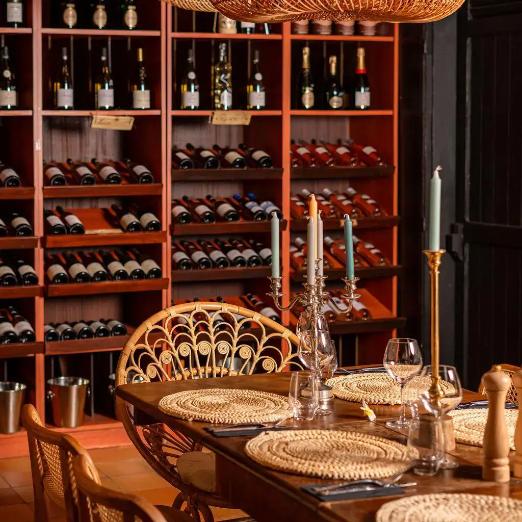 Tables de restaurant sous une structure blanche avec voilages et suspensions design au Boho Saint-Gilles.